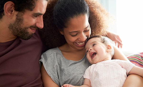 parents holding their baby and smiling